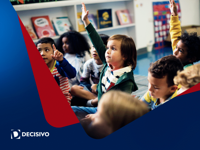 Crianças participam de atividade em sala, levantando a mão e exercitando autonomia na vida escolar desde cedo.